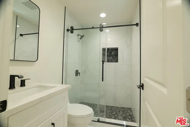 a bathroom with a shower toilet and sink