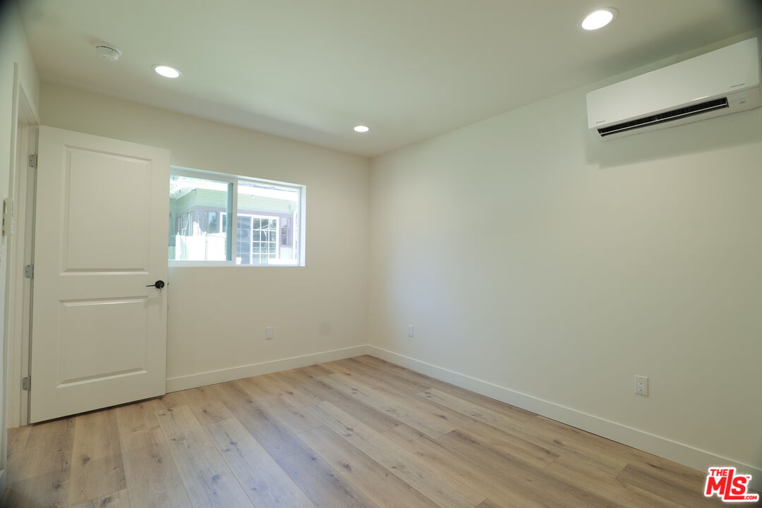 1338 West 30th Street Los Angeles, CA 90007 - Photo 10 of 21 an empty room with wooden floor and windows