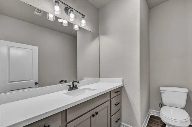 a bathroom with a sink a toilet and a mirror