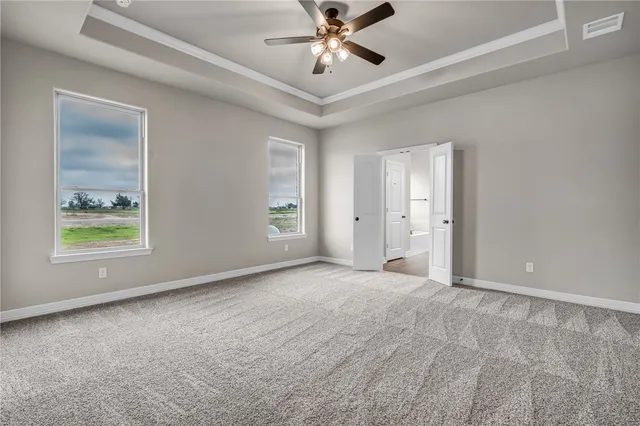 an empty room with window and ceiling fan