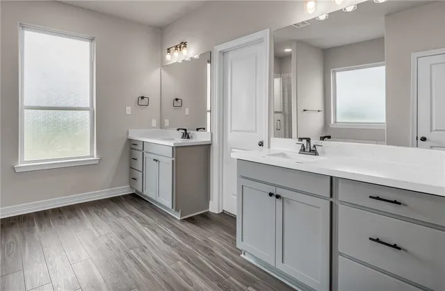 a spacious bathroom with a double vanity sink a mirror and a bathtub
