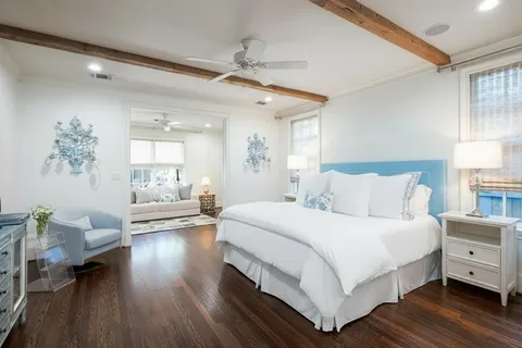 a bedroom with a large bed and a wooden floor