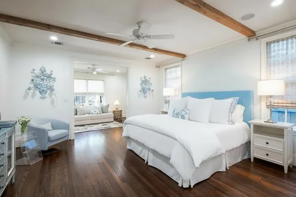 a bedroom with a large bed and a wooden floor
