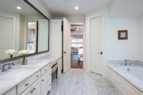 a spacious bathroom with a granite countertop sink mirror and bathtub
