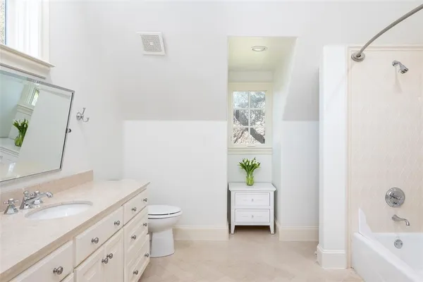 a bathroom with a granite countertop sink a toilet and shower