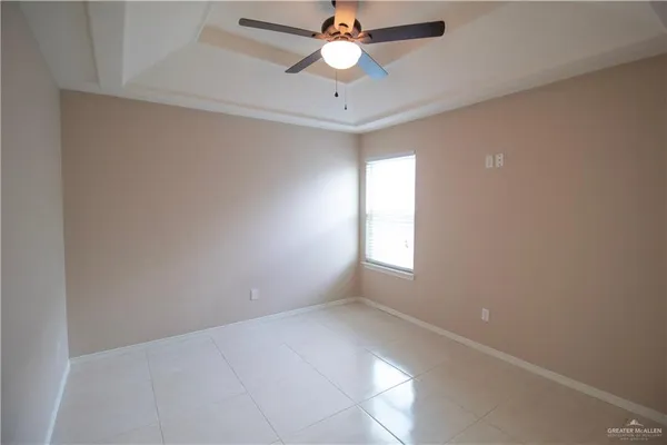 an empty room with ceiling fan and window
