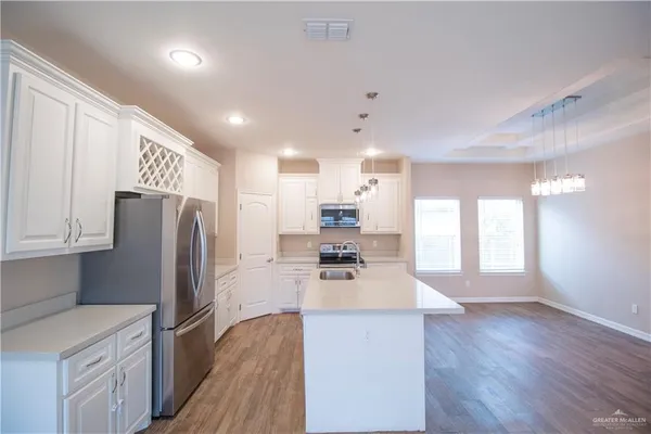 a kitchen with stainless steel appliances a refrigerator sink and microwave