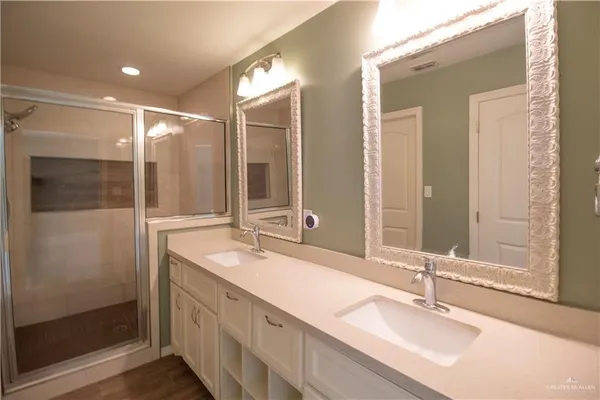 a bathroom with double vanity and a mirror