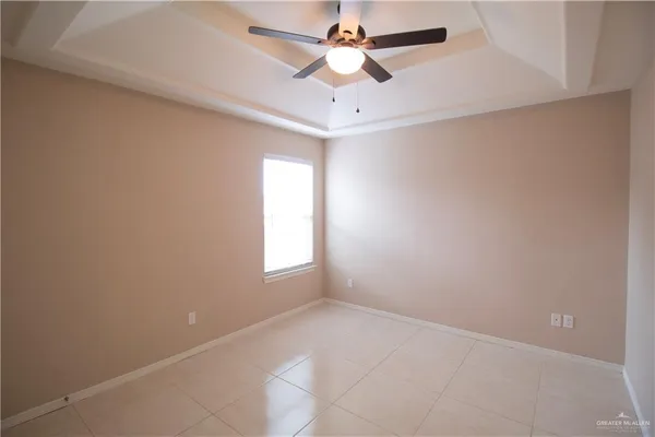 an empty room with a window and a fan