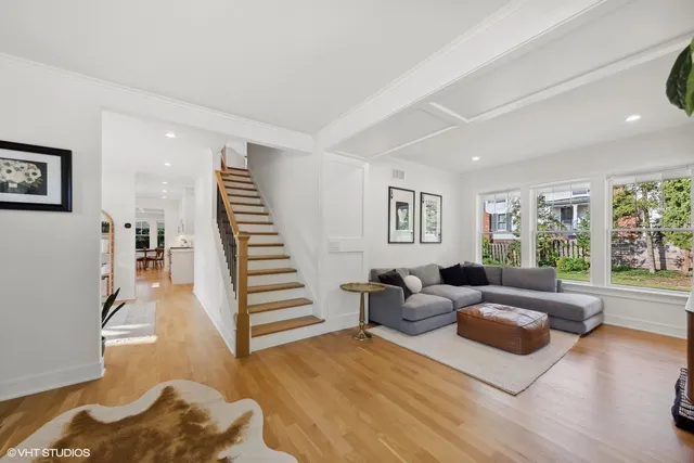 a kitchen with stainless steel appliances white cabinets a sink dishwasher a stove and a refrigerator with wooden floor