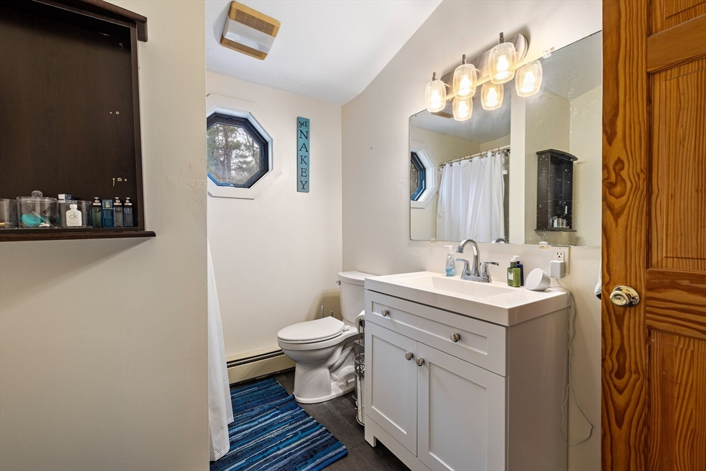 404 Rawson Street, Unit 404 Leicester, MA 01524 - Photo 11 of 13 a bathroom with a toilet a sink and mirror