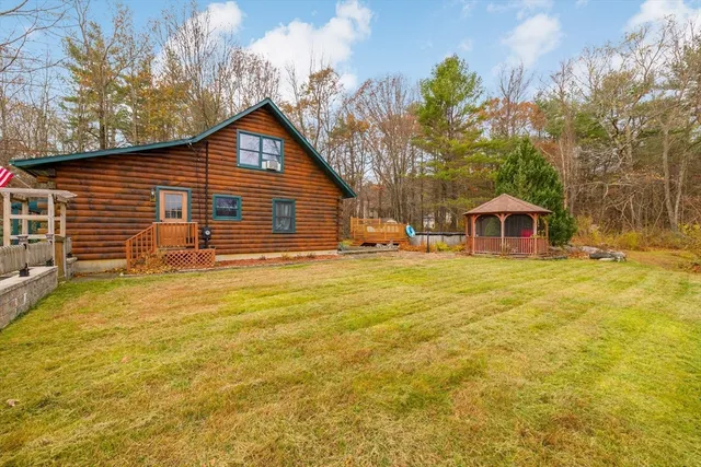 a front view of house with yard and trees in the background