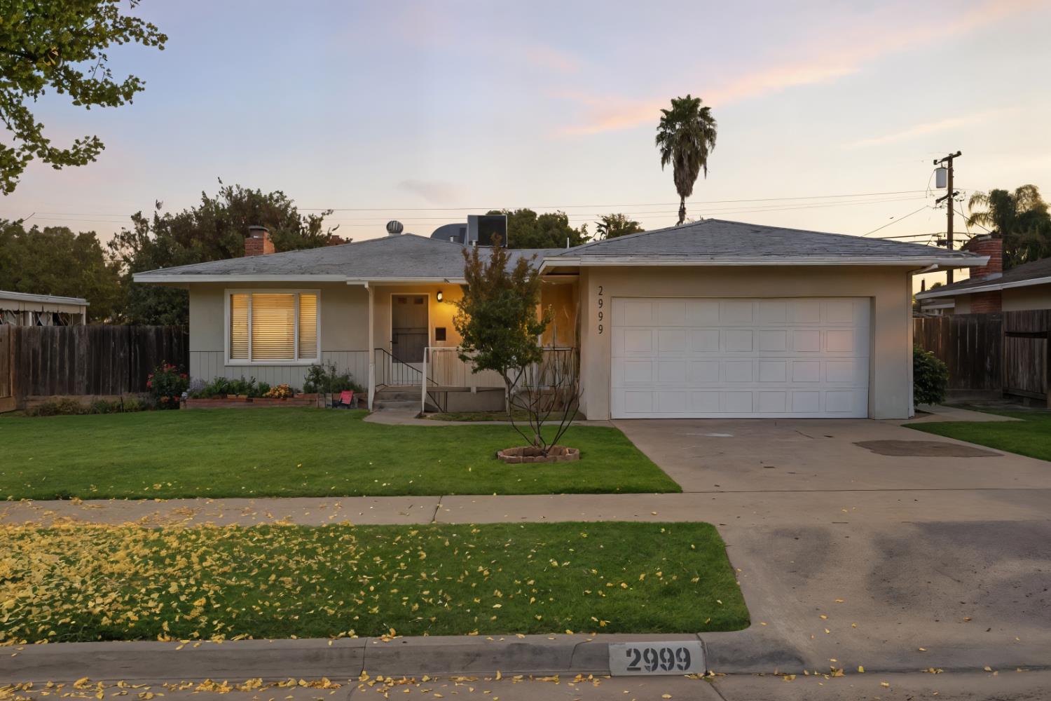 2999 East Richert Avenue Fresno, CA 93726 - Photo 2 of 19 a front view of a house with a yard and garage