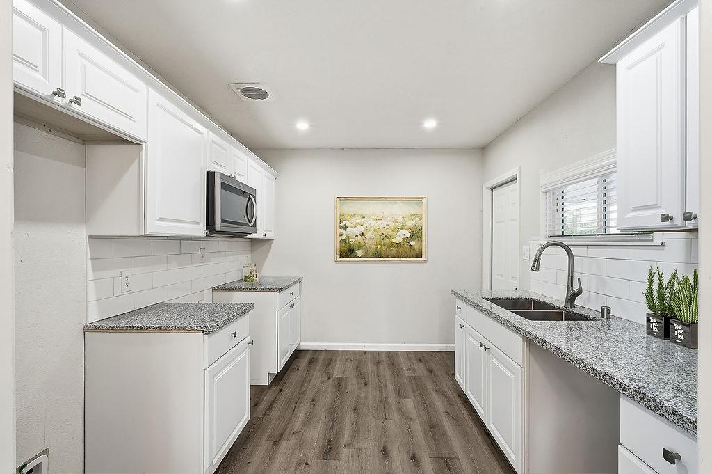 2999 East Richert Avenue Fresno, CA 93726 - Photo 4 of 19 a kitchen with granite countertop a sink stainless steel appliances and white cabinets