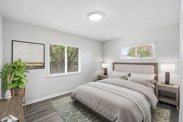 a bedroom with a bed potted plant and a window