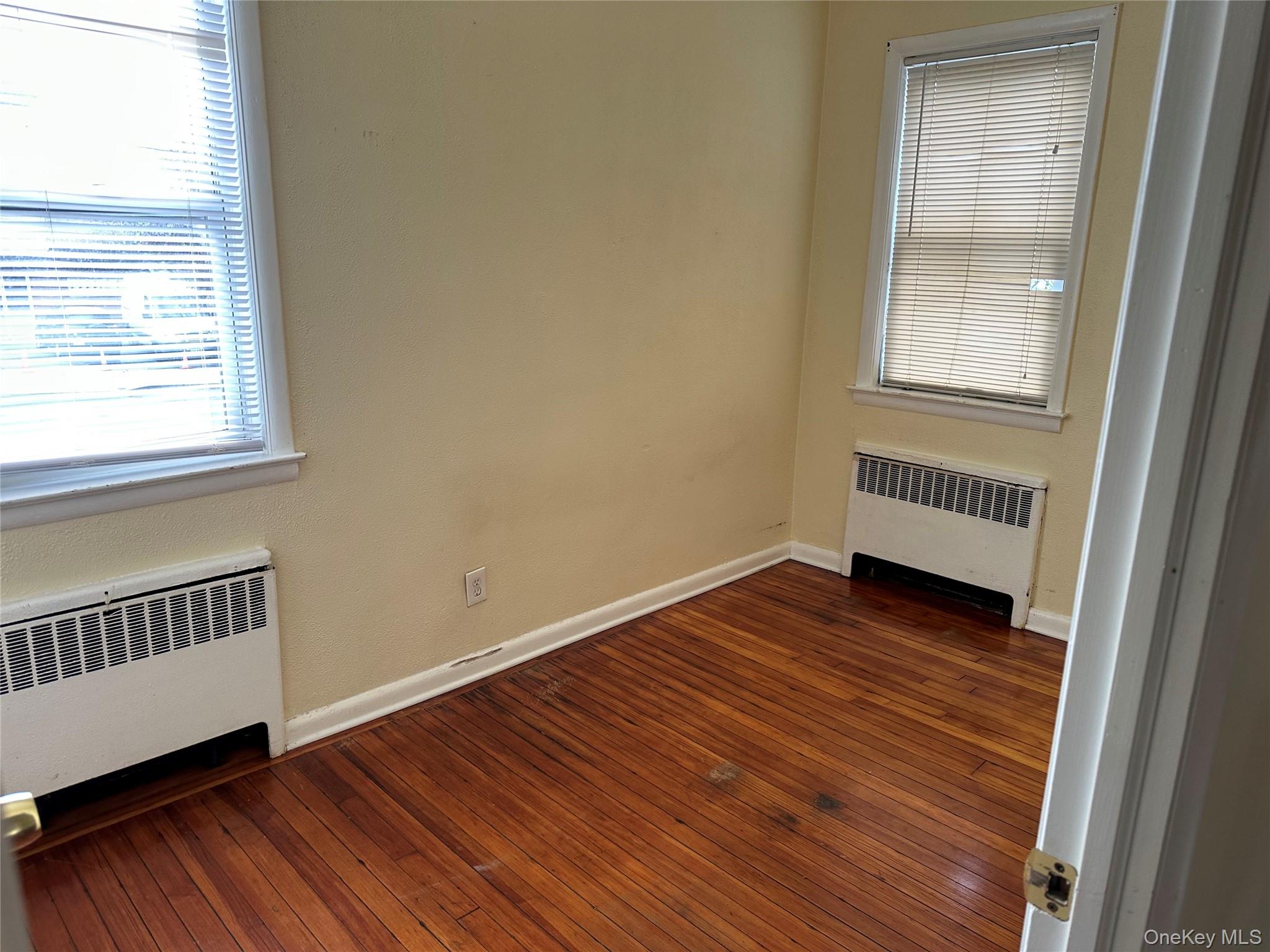 9 Webster Avenue, Unit 1 New Rochelle, NY 10801 - Photo 4 of 7 a view of an empty room with wooden floor and a window