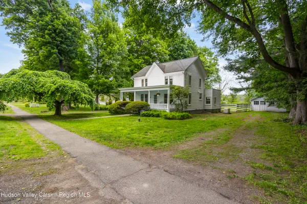 a front view of a house with a yard tree and green space
