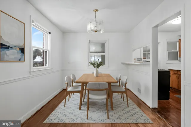 a dining room with wooden floor a chandelier a wooden table and chairs