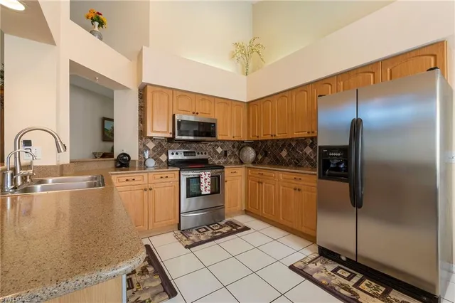 a kitchen with a refrigerator a sink and cabinets