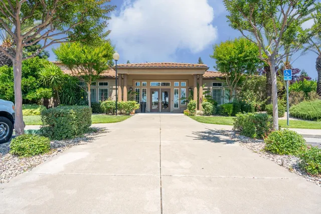 a view of a house with a small yard and palm trees