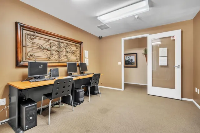a view of a workspace with furniture and a window