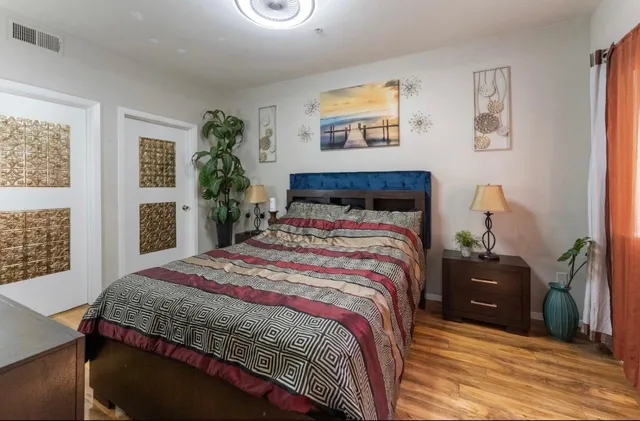 a bedroom with a bed and a lamp on dresser