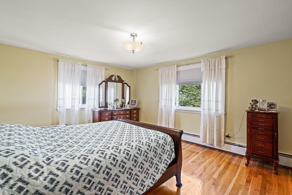 23 Webster Road Lexington, MA 02421 - Photo 12 of 32 a bedroom with a large bed and wooden floor