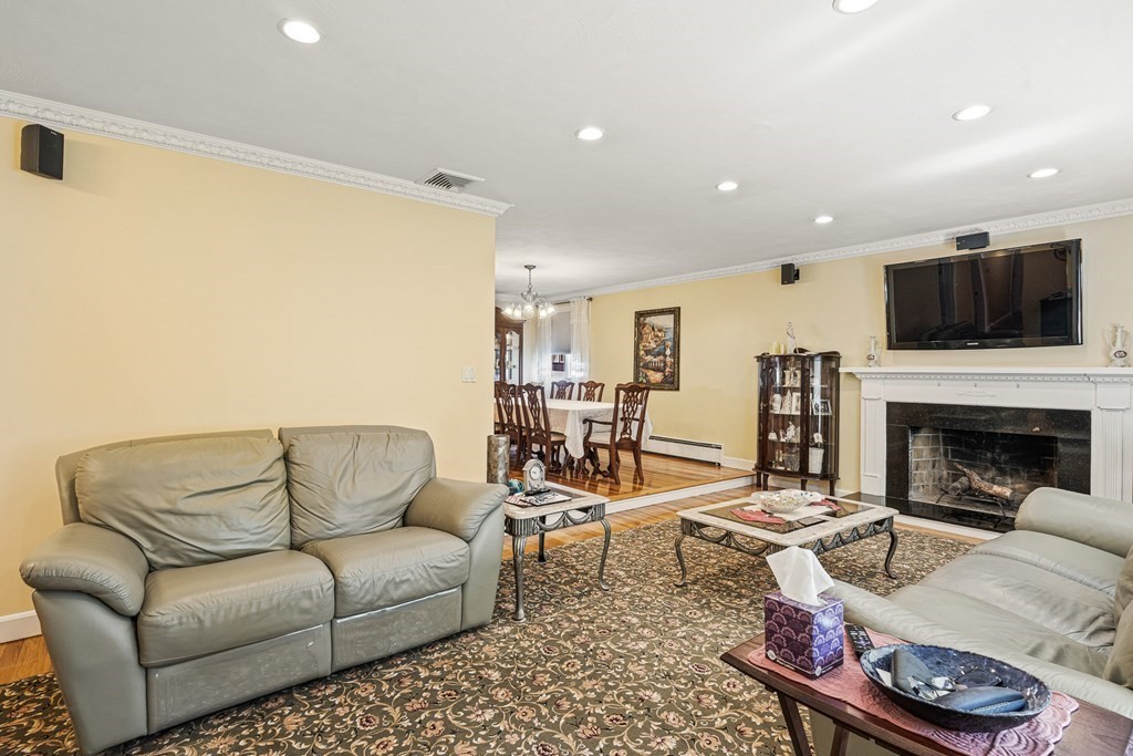 23 Webster Road Lexington, MA 02421 - Photo 7 of 32 a living room with furniture a flat screen tv and a fireplace
