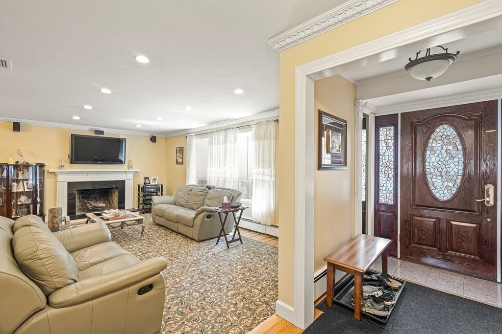 23 Webster Road Lexington, MA 02421 - Photo 10 of 32 a living room with furniture a fireplace and a chandelier