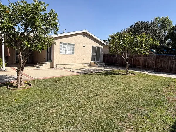 a view of a white house next to a yard