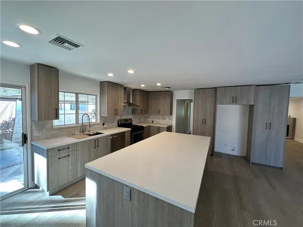 a large kitchen with a refrigerator a sink dishwasher with a dining table and chairs