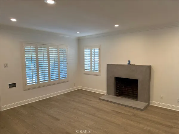 an empty room with windows and fireplace