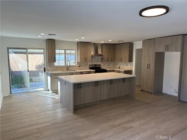 a kitchen with a sink cabinets and wooden floor