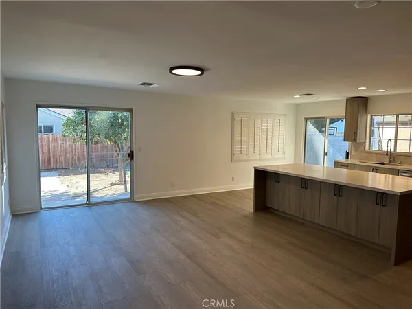 a view of a kitchen with wooden floor and a sink