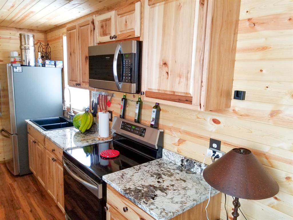 350 Summerfield Court Springtown, TX 76082 - Photo 5 of 20 a kitchen with stainless steel appliances granite countertop a stove a sink and a microwave