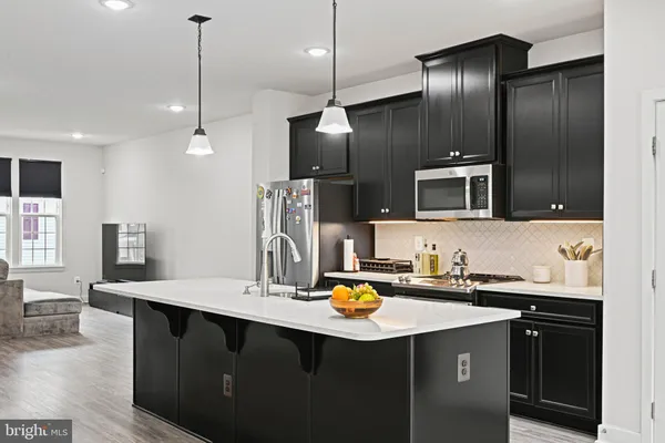 a kitchen with sink refrigerator and microwave