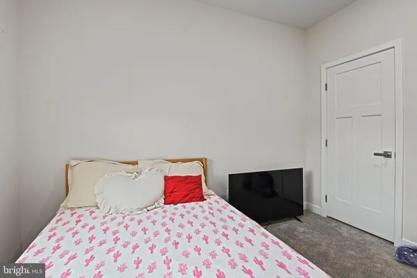 a bedroom with a bed and a lamp on dresser