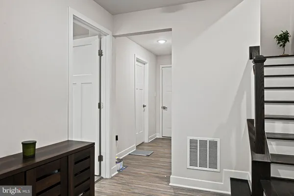 a view of a hallway with wooden floor and cabinet