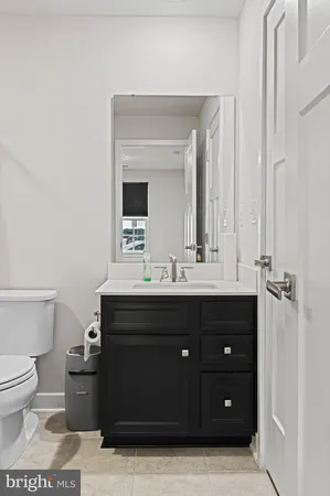 a bathroom with a sink vanity mirror and toilet