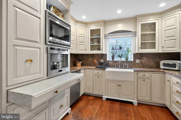a kitchen with stainless steel appliances white cabinets and wooden floors
