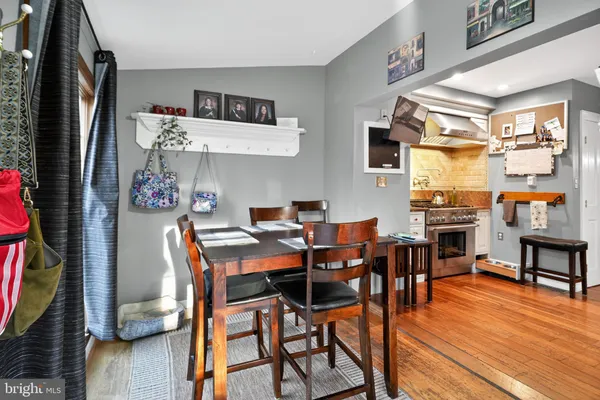 a dining room with stainless steel appliances granite countertop a dining table and chairs with wooden floor