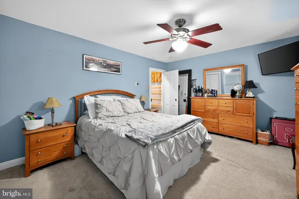 a spacious bedroom with a bed and a tv