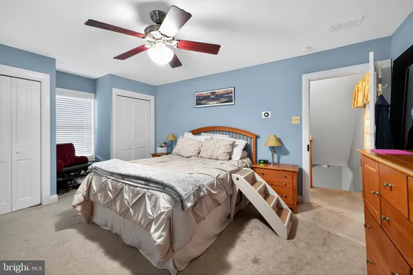 a spacious bedroom with a bed and a chandelier