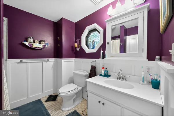 a bathroom with a toilet a sink and a large mirror