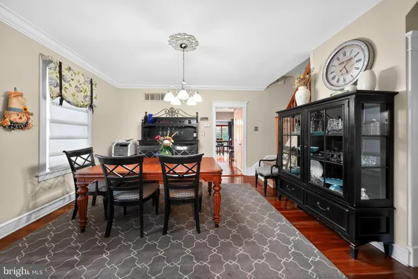 a dining room with furniture a chandelier and wooden floor