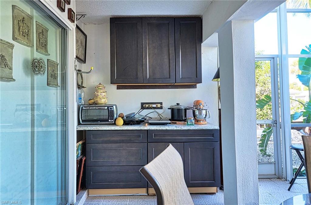 14 Watercolor Way, Unit 14 Naples, FL 34113 - Photo 13 of 28 a kitchen with granite countertop wooden cabinets and a refrigerator