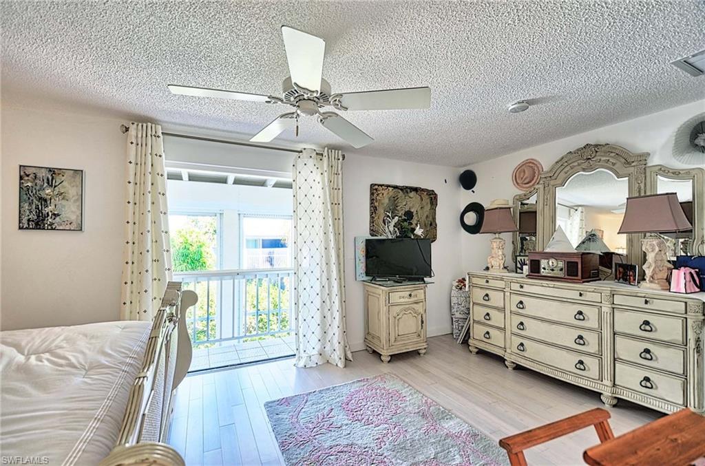 14 Watercolor Way, Unit 14 Naples, FL 34113 - Photo 19 of 28 a bed room with a bed and a television