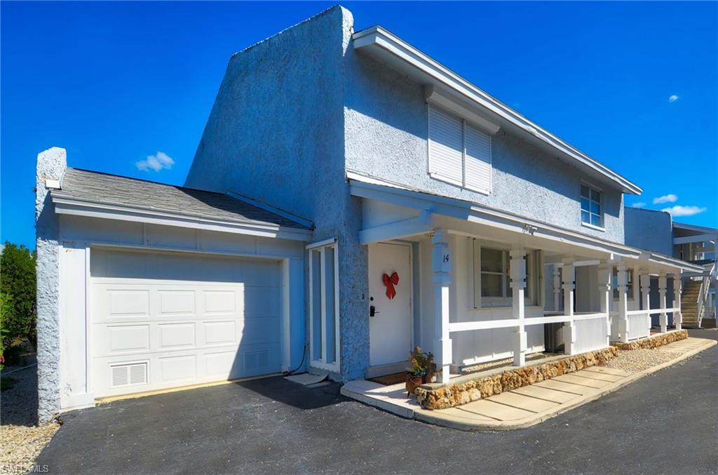 14 Watercolor Way, Unit 14 Naples, FL 34113 - Photo 2 of 28 a front view of a house with a garage