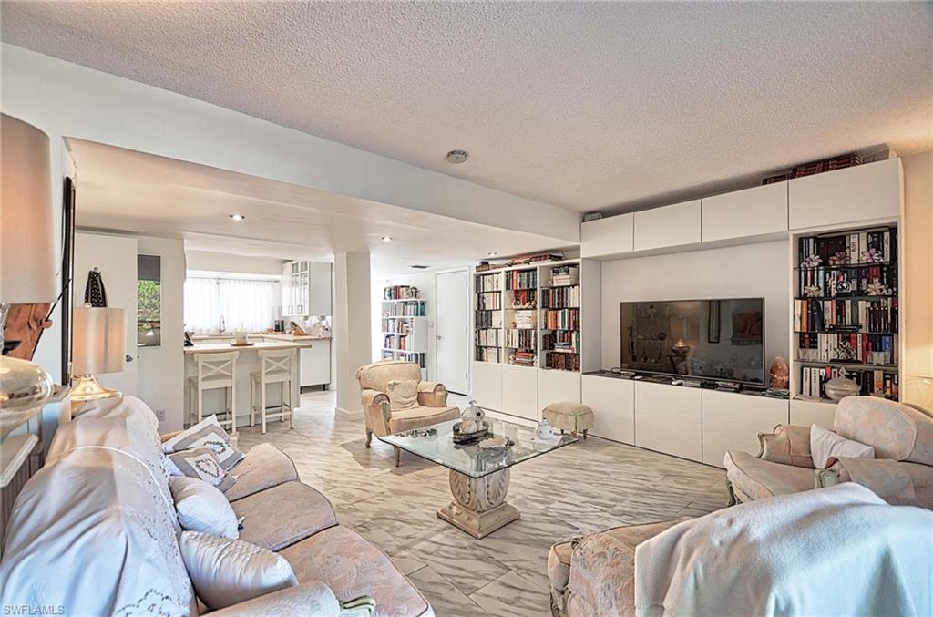 14 Watercolor Way, Unit 14 Naples, FL 34113 - Photo 6 of 28 a living room with furniture a flat screen tv and a large window