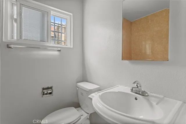 a white toilet sitting next to a bathroom sink
